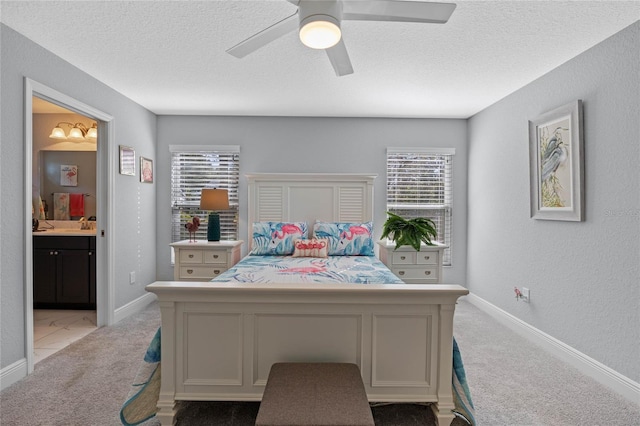 carpeted bedroom featuring ensuite bathroom, ceiling fan, and a textured ceiling