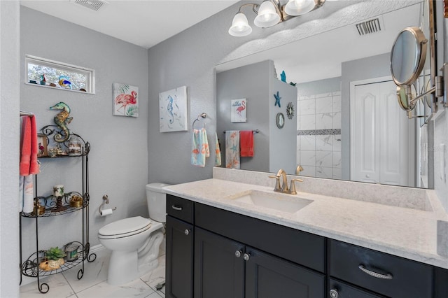 bathroom featuring vanity, toilet, and walk in shower