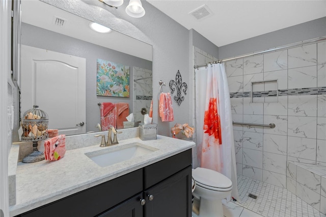 bathroom with toilet, vanity, and walk in shower