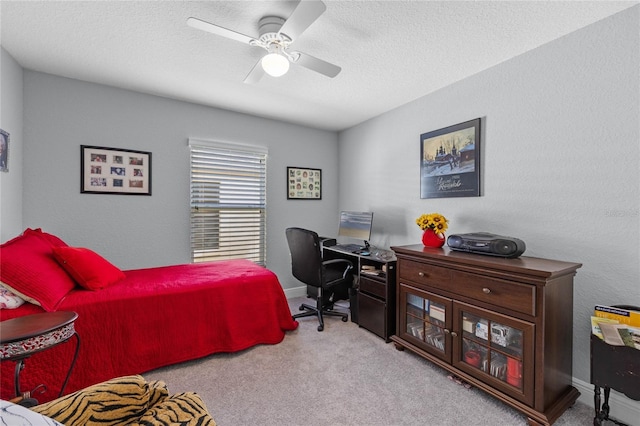 bedroom featuring light carpet, a textured ceiling, and ceiling fan