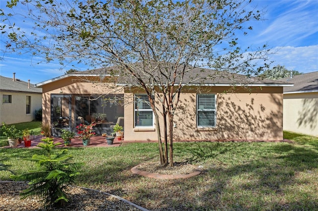 rear view of property with a lawn and a patio area