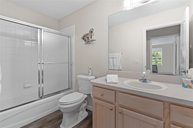 bathroom with vanity, a textured ceiling, toilet, and wood finished floors