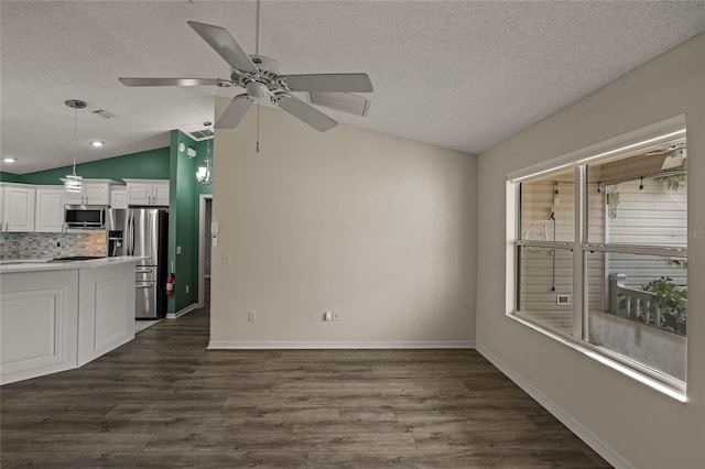 interior space with vaulted ceiling, ceiling fan, a textured ceiling, and dark hardwood / wood-style flooring