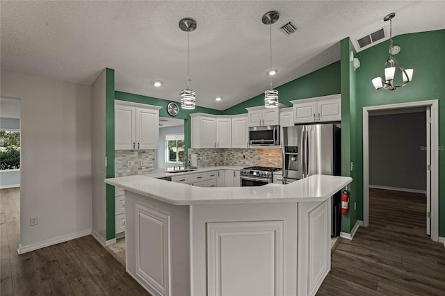 kitchen with white cabinetry, a kitchen island, decorative backsplash, lofted ceiling, and stainless steel appliances