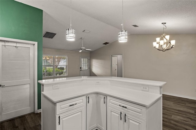 kitchen featuring a textured ceiling, white cabinetry, decorative light fixtures, dark hardwood / wood-style floors, and lofted ceiling