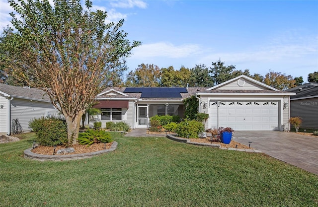 ranch-style house featuring a garage, a front lawn, and solar panels