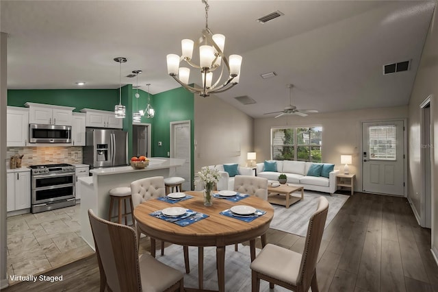 dining space featuring lofted ceiling, ceiling fan with notable chandelier, and light hardwood / wood-style flooring