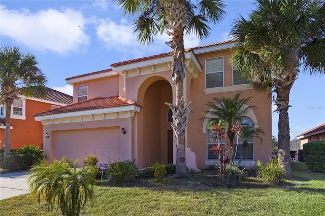 mediterranean / spanish-style house with a garage and a front yard