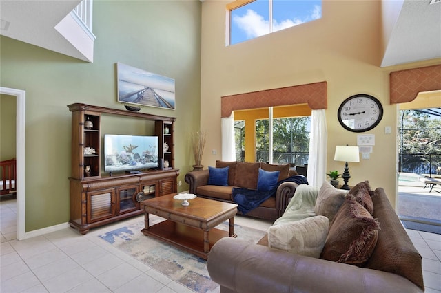 living room featuring a towering ceiling and light tile patterned floors