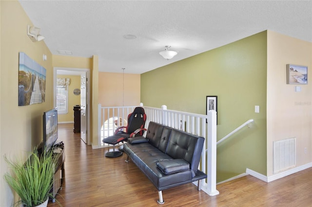 living area with hardwood / wood-style floors and a textured ceiling