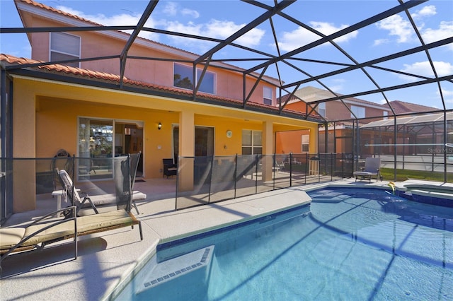 view of pool with an in ground hot tub, a patio, and glass enclosure