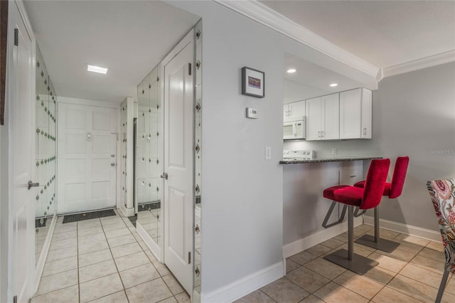 interior space with light tile patterned floors and ornamental molding