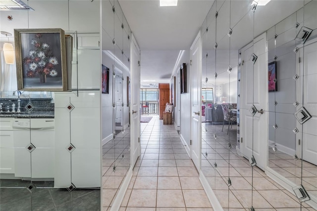 corridor with light tile patterned floors and sink