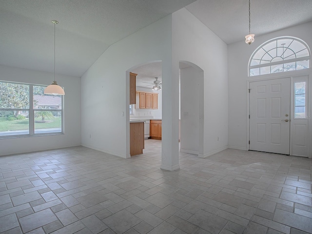 foyer entrance featuring ceiling fan, lofted ceiling, and a textured ceiling