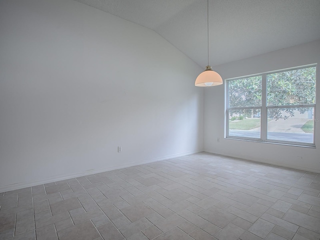 spare room with a textured ceiling and vaulted ceiling