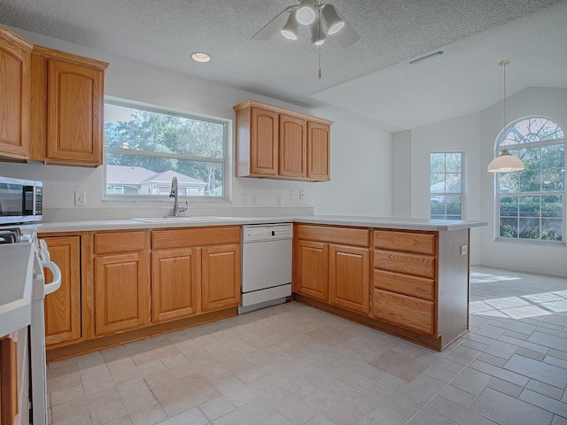 kitchen featuring stove, a textured ceiling, white dishwasher, hanging light fixtures, and lofted ceiling