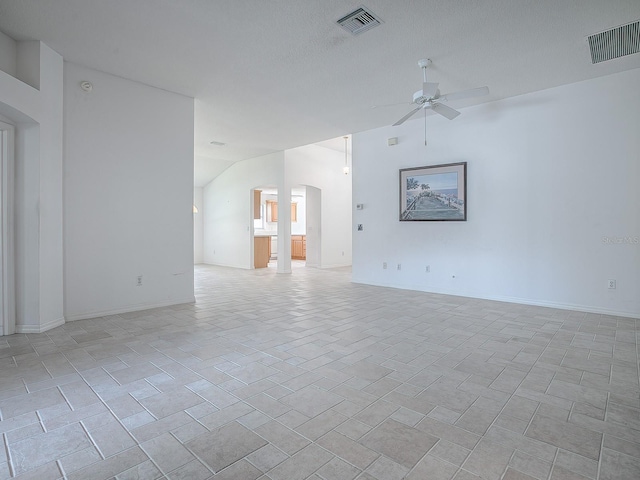 empty room with a textured ceiling, ceiling fan, and vaulted ceiling