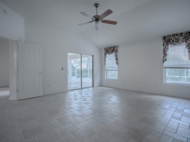 empty room featuring vaulted ceiling, a wealth of natural light, and ceiling fan