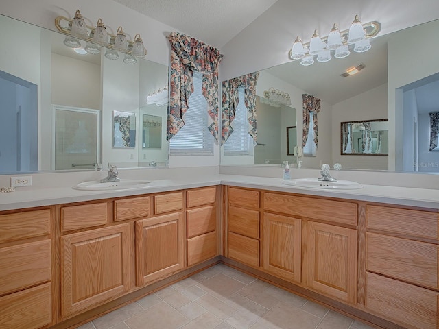 bathroom with tile patterned floors, a textured ceiling, vanity, a shower with door, and lofted ceiling