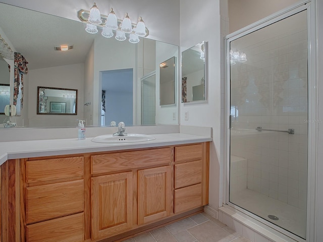 bathroom with tile patterned floors, a shower with door, and vanity