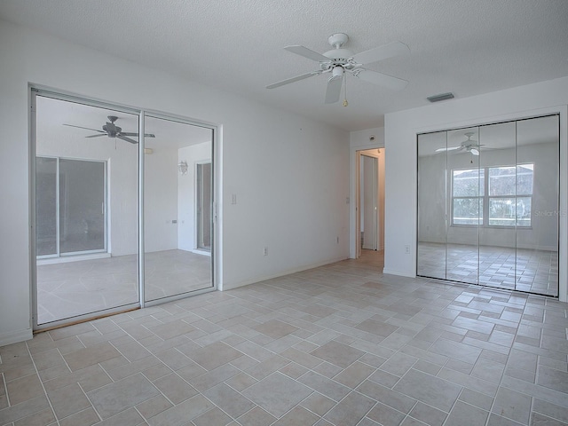 unfurnished bedroom with ceiling fan and a textured ceiling