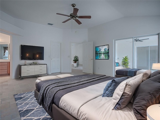 tiled bedroom featuring ceiling fan, ensuite bathroom, and lofted ceiling