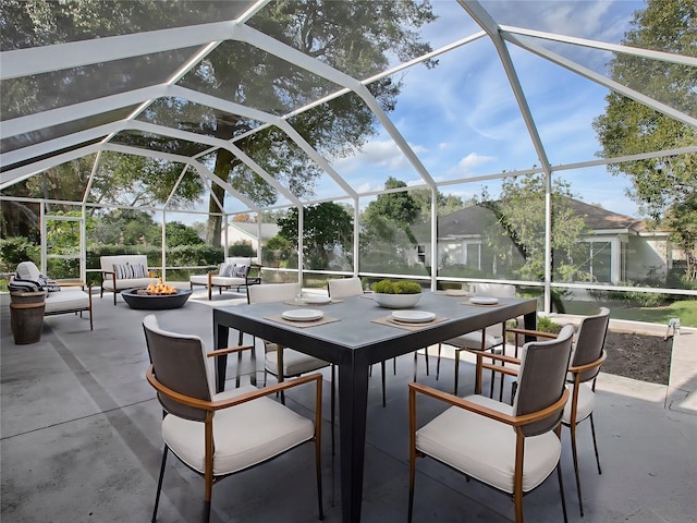 view of patio / terrace featuring glass enclosure and a fire pit