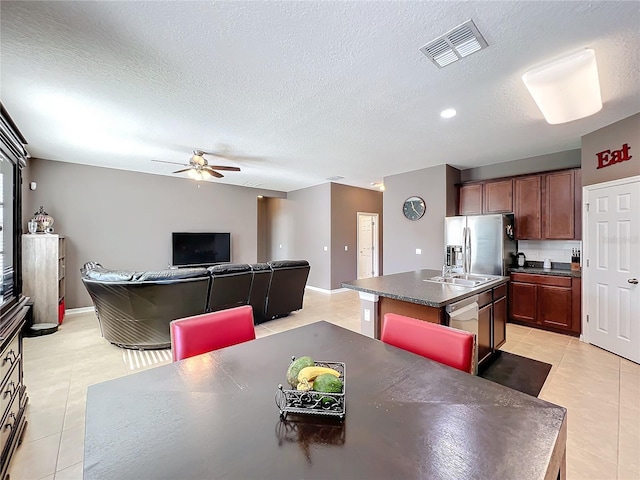 dining space featuring a textured ceiling, light tile patterned flooring, and visible vents