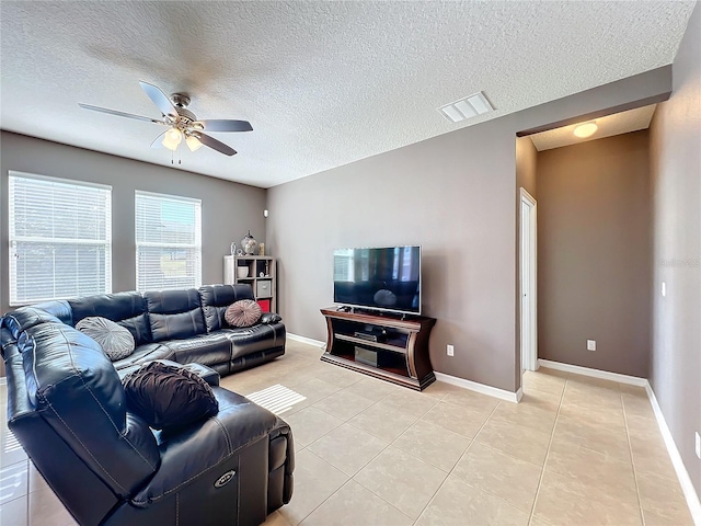 living room with visible vents, ceiling fan, baseboards, and light tile patterned floors