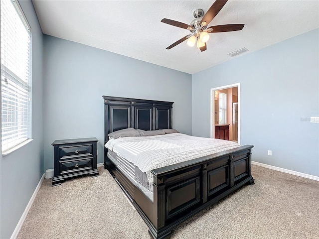 bedroom with visible vents, light carpet, baseboards, and a textured ceiling