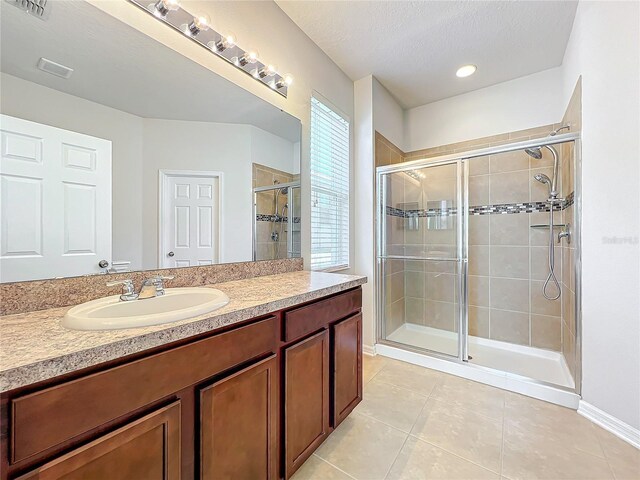 full bathroom with visible vents, a shower stall, vanity, a textured ceiling, and tile patterned flooring