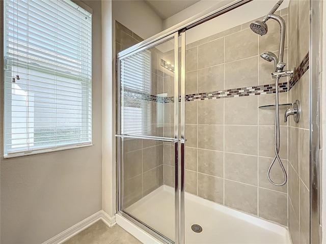 full bathroom featuring a stall shower, baseboards, and tile patterned floors