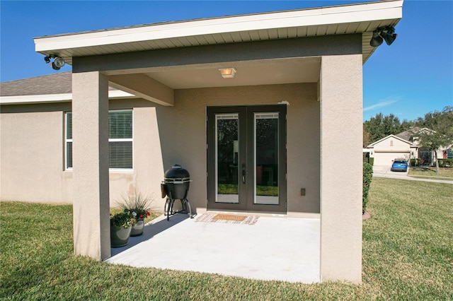 property entrance with a shingled roof, french doors, a lawn, and stucco siding