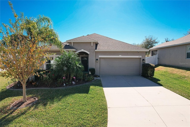 view of front facade featuring concrete driveway, an attached garage, a front lawn, and stucco siding