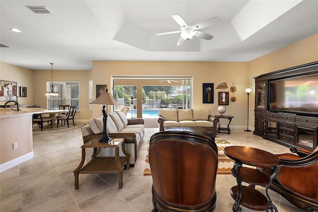 tiled living room with ceiling fan and a textured ceiling