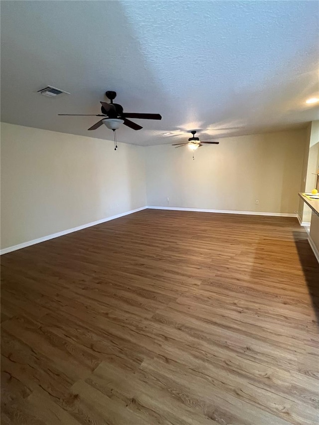 unfurnished room featuring wood-type flooring and a textured ceiling