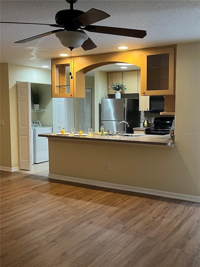 kitchen featuring hardwood / wood-style floors, a textured ceiling, ceiling fan, and black appliances