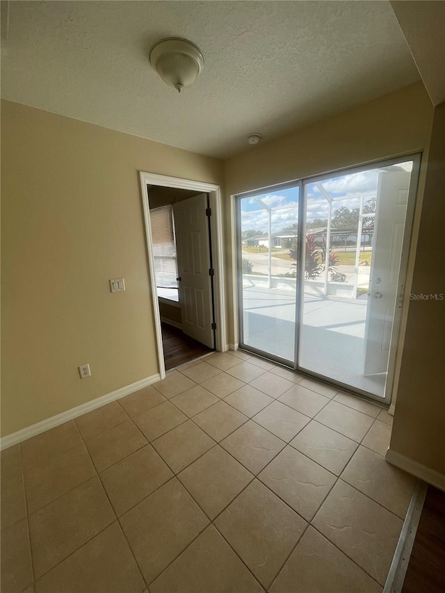 tiled spare room with a textured ceiling