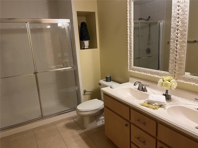 bathroom with toilet, vanity, tile patterned floors, and walk in shower