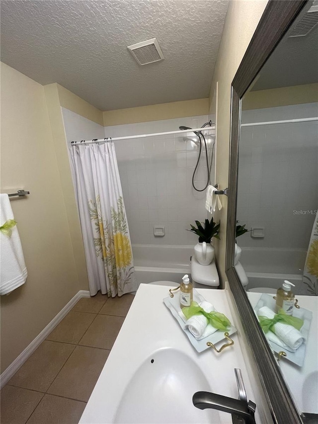 bathroom with tile patterned flooring, shower / bathtub combination with curtain, and a textured ceiling