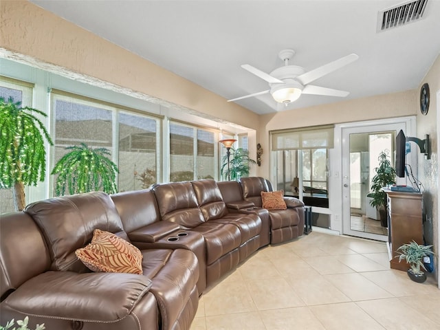 tiled living room with a wealth of natural light and ceiling fan