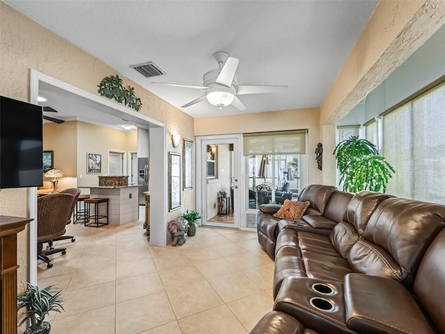 living room featuring light tile patterned floors and ceiling fan