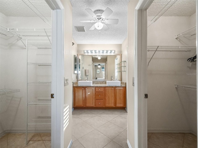 bathroom featuring a textured ceiling, vanity, tile patterned floors, and ceiling fan