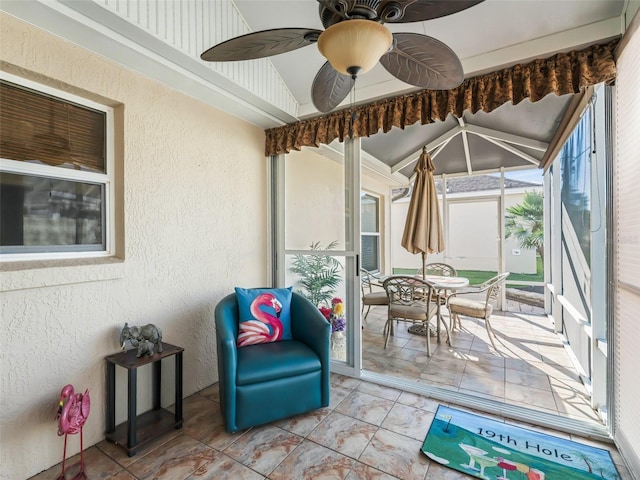 sunroom / solarium featuring ceiling fan and vaulted ceiling