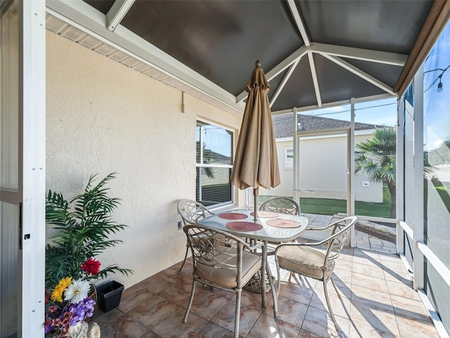 sunroom / solarium featuring plenty of natural light and lofted ceiling