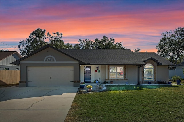 ranch-style house featuring a lawn and a garage