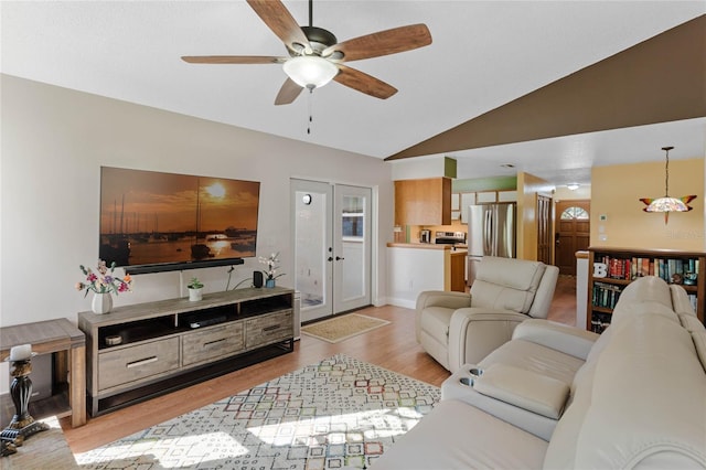 living room with french doors, light hardwood / wood-style floors, vaulted ceiling, and ceiling fan