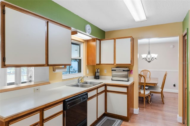 kitchen with dishwasher, pendant lighting, white cabinetry, and sink