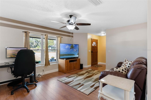 office space with a textured ceiling, hardwood / wood-style flooring, and ceiling fan