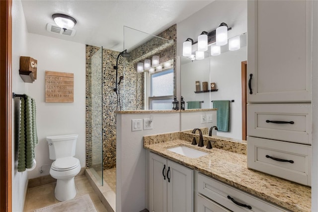 bathroom featuring tile patterned floors, vanity, toilet, and a shower